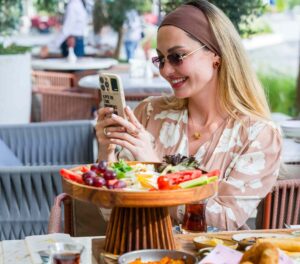 A woman enjoying breakfast outdoors at Dubai Creek Harbour