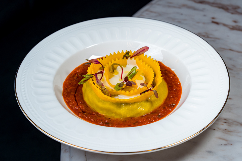 Cooked pasta served in a plate with red sauce
