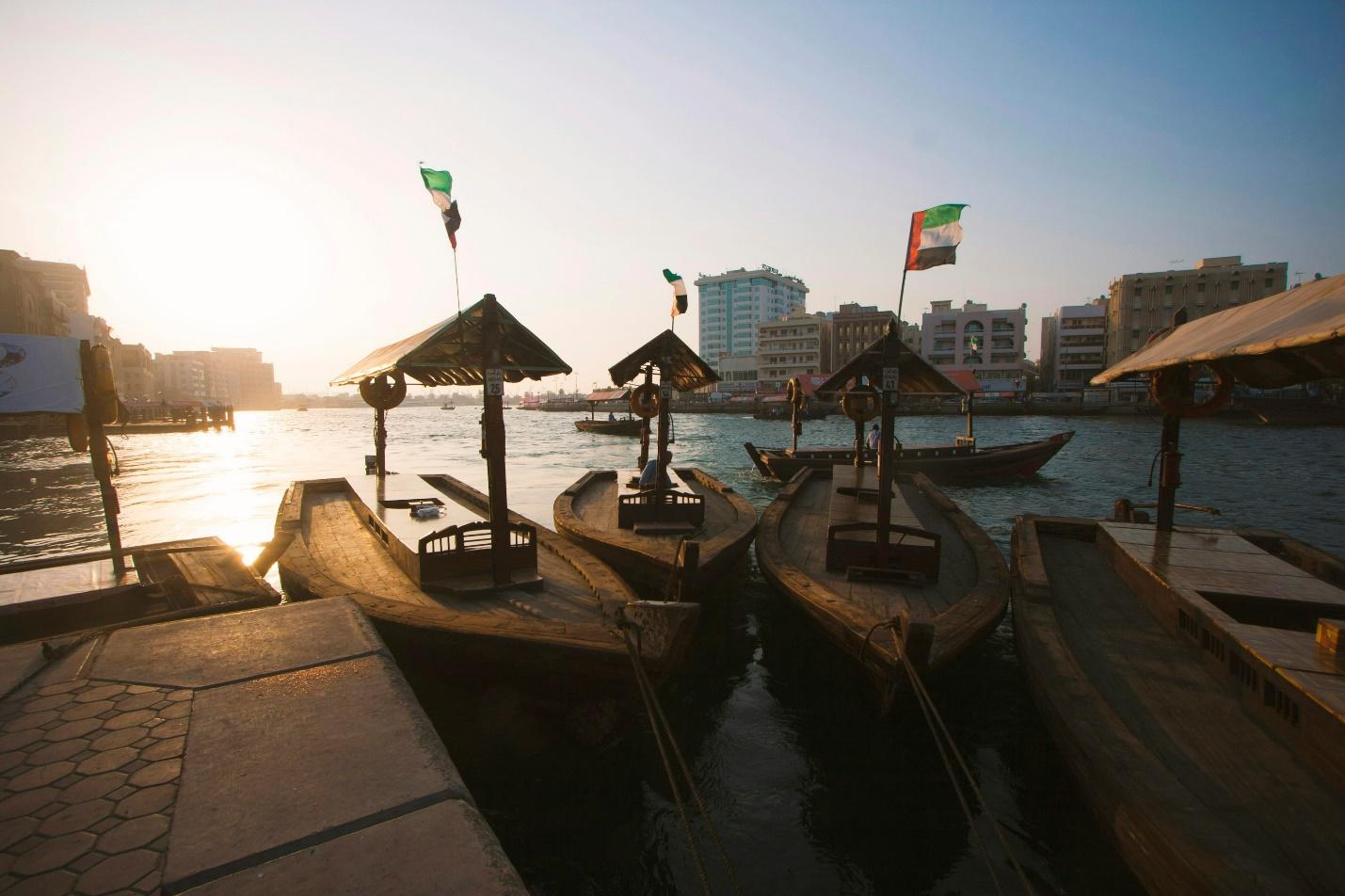 The creek of Dubi with boats and UAE flags