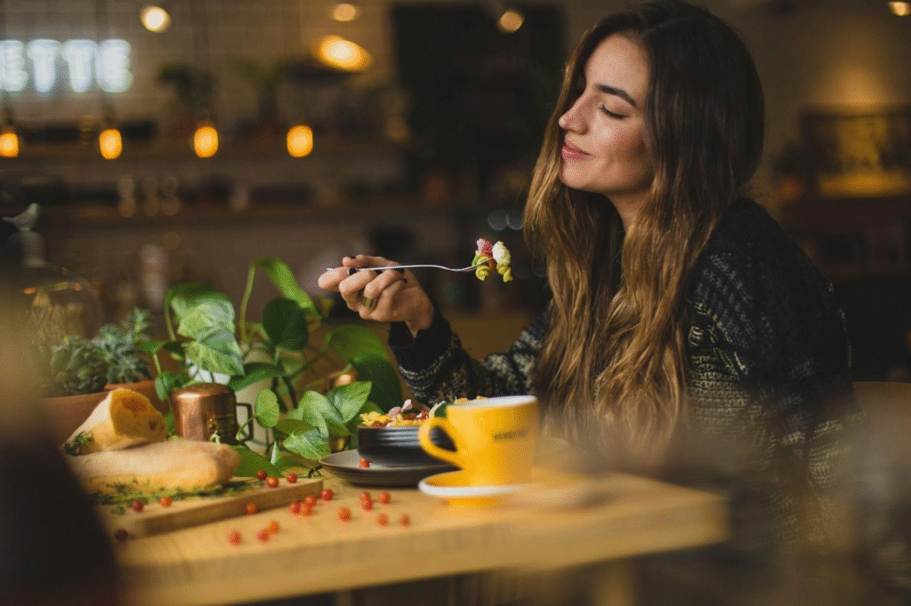 A woman smiling while eating food